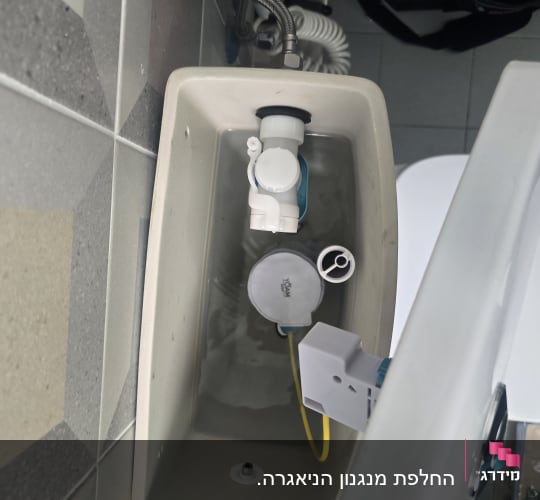 פנים ניאגרה גלויה פתוחה בעת טיפול במנגנון ההדחה